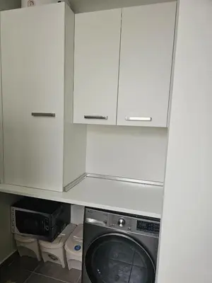 a kitchen with white cabinets and a washing machine at Gratitude Apartment in Funchal