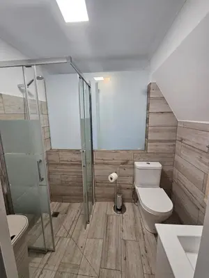 a bathroom with a toilet and a glass shower at Bela Vista House in Funchal