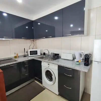 a kitchen with a washing machine and a microwave at Sol I in Funchal