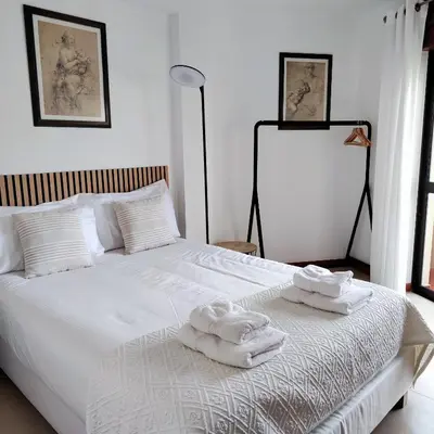 a bedroom with a white bed with towels on it at Sol I in Funchal