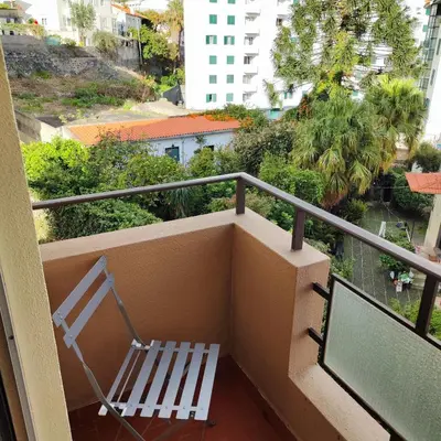 a balcony with a bench and a view of a city at Sol I in Funchal