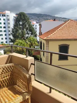 a wicker chair sitting on the balcony of a building at Sol I in Funchal