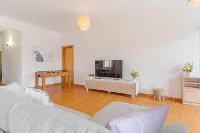 a living room with a white couch and a table at Casa Mieiro - Porto Santo in Porto Santo