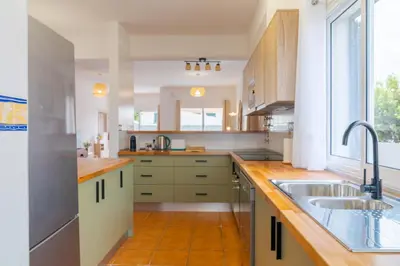 a large kitchen with a sink and a window at Casa Mieiro - Porto Santo in Porto Santo