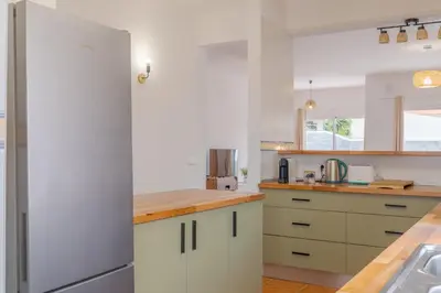 a kitchen with white cabinets and a refrigerator at Casa Mieiro - Porto Santo in Porto Santo