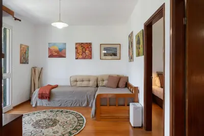 a bedroom with a bed and a couch in it at Retiro do Artista art and views over the valley in São Vicente