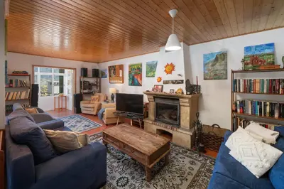 a living room with a couch and a fireplace at Retiro do Artista art and views over the valley in São Vicente