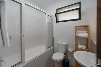 a bathroom with a shower and a toilet and a sink at Retiro do Artista art and views over the valley in São Vicente