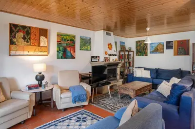 a living room with blue couches and a fireplace at Retiro do Artista art and views over the valley in São Vicente