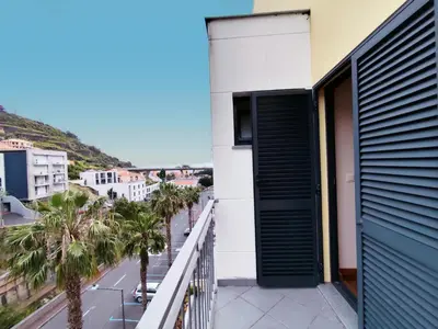 a balcony with a green door and palm trees at Coastal Comfort at Riverside - 4 Min to Airport! in Santa Cruz