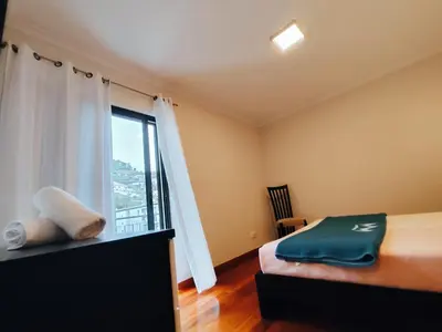 a bedroom with a bed and a large window at Coastal Comfort at Riverside - 4 Min to Airport! in Santa Cruz