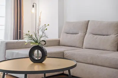 a living room with a couch and a table with a vase on it at Nara by KAAMAH in Santa Cruz