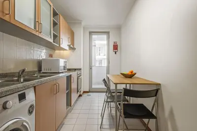 a kitchen with a sink and a table with chairs at Nara by KAAMAH in Santa Cruz
