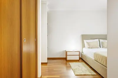a bedroom with a bed and a table with a rug at Nara by KAAMAH in Santa Cruz