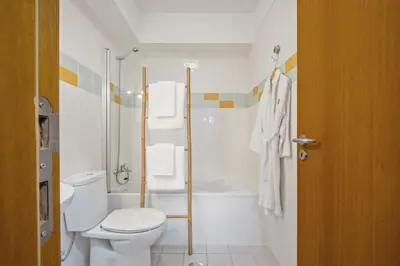 a white bathroom with a toilet and a shower at Nara by KAAMAH in Santa Cruz