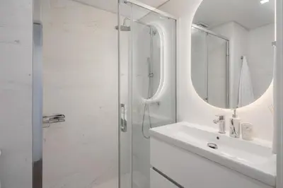 a white bathroom with a shower and a sink at Acqua Residence VII - Luxury 3BR in Funchal in Funchal
