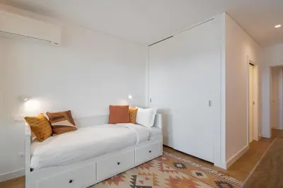 a white room with a bed with pillows on it at Acqua Residence VII - Luxury 3BR in Funchal in Funchal