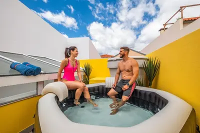 a man and woman sitting in a hot tub on a house at SUPER Rabbit in Funchal