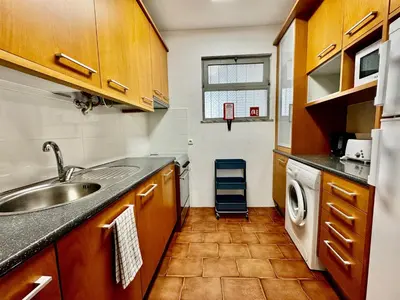 a kitchen with a sink and a washing machine at O Mar a dois minutos in Luz