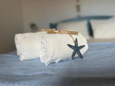 a white towel with a star on top of a bed at O Mar a dois minutos in Luz