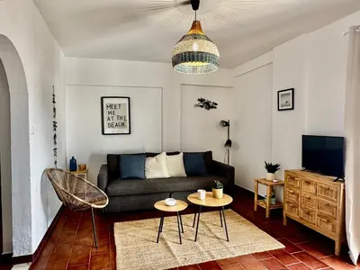 a living room with a couch and a tv at O Mar a dois minutos in Luz