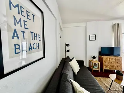 a living room with a couch and a picture on the wall at O Mar a dois minutos in Luz