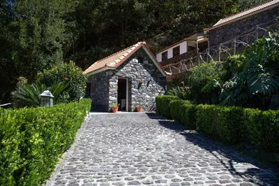 a stone path leading to a building with a door at Portas da Levada B by Rent-a-key in São Vicente
