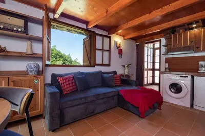 a living room with a couch and a washing machine at Portas da Levada B by Rent-a-key in São Vicente