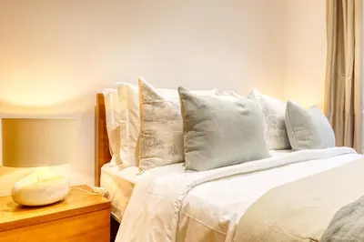 a bedroom with a bed with white sheets and pillows at Casa do Pinheiro II, a Home in Madeira in São Vicente