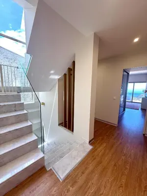 a staircase in a home with white walls and wood floors at Villa Amazing View Funchal - Lux & Pool in Funchal