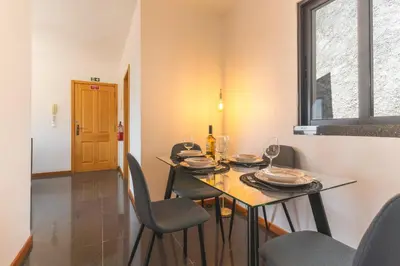 a dining room with a table and chairs and a window at Porlamar Apartment by Atlantic Holiday in Calheta