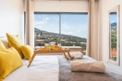 a living room with a table and a large window at Porlamar Apartment by Atlantic Holiday in Calheta