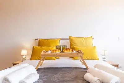 a bed with yellow pillows and a tray of pastries at Porlamar Apartment by Atlantic Holiday in Calheta