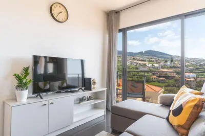 a living room with a tv and a large window at Porlamar Apartment by Atlantic Holiday in Calheta