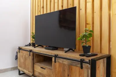 a flat screen tv on a wooden entertainment center at A20 - Beco Luz Studio in Luz