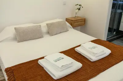 a white bed with two towels on top of it at A20 - Beco Luz Studio in Luz