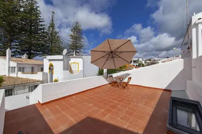 a patio with a large umbrella on top of a building at A20 - Beco Luz Studio in Luz