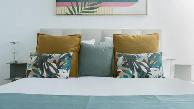 a bed with three pillows and a white bedsheet at CasaNova by LovelyStay in Santa Cruz