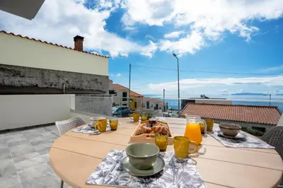 a table with food and orange juice on a balcony at CasaNova by LovelyStay in Santa Cruz