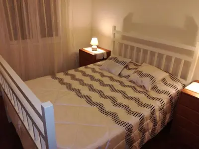 a white bed in a bedroom with a lamp at Casa do Pico in Câmara de Lobos