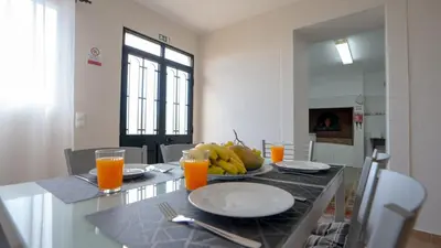 a dining room table with a plate of bananas and orange juice at Marroas Cottage in Ponta do Sol