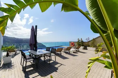 a patio with tables and chairs and a view at Villa António in Arco da Calheta