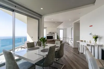 a dining room and living room with a table and chairs at Villa António in Arco da Calheta