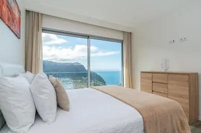 a bedroom with a bed with a large window at Villa António in Arco da Calheta