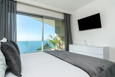 a bedroom with a large bed with a large window at Villa António in Arco da Calheta