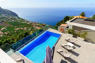 a swimming pool on the roof of a house at Villa António in Arco da Calheta