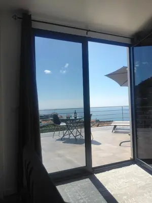 a table with a plate of food on a balcony at Pearl Of The Sea in Ponta do Sol