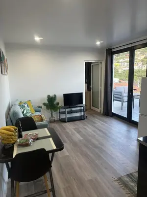 a kitchen and a living room with a couch and a table at Pearl Of The Sea in Ponta do Sol