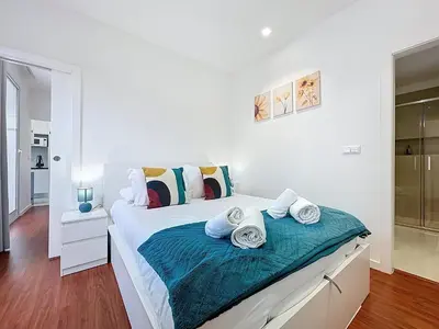 a white bedroom with a bed with towels on it at CityZen Funchal by Atlantic Holiday in Funchal