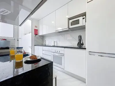a white kitchen with a counter with a plate of food at CityZen Funchal by Atlantic Holiday in Funchal